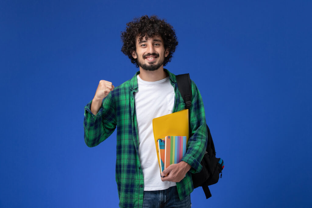 front-view-male-student-wearing-black-backpack-holding-copybooks-files-blue-wall-1024x683 Sistemas de Informação 2025: Onde estudar, sobre o curso e Inscrição